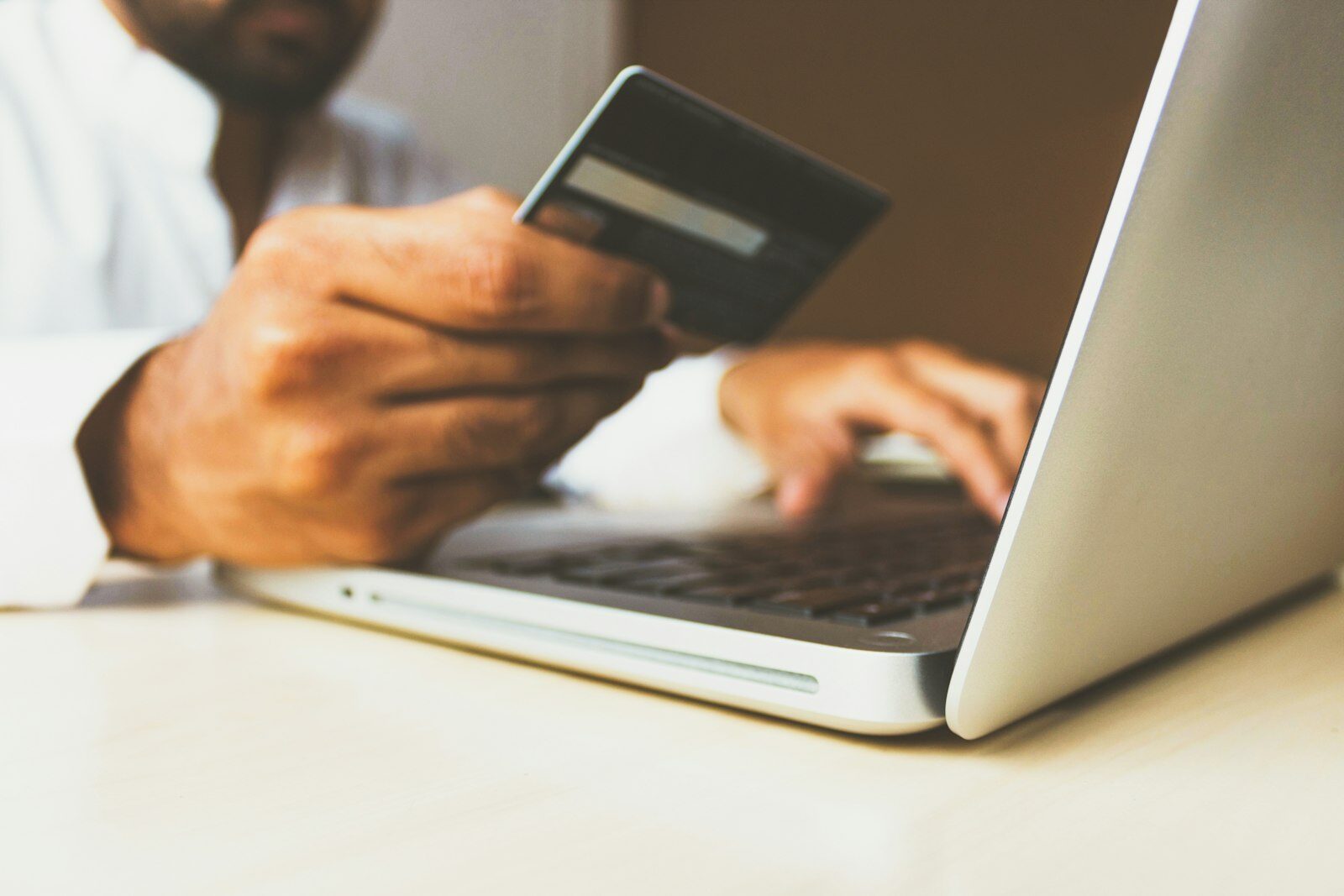 A person using a smartphone and credit card to make an online rent payment.