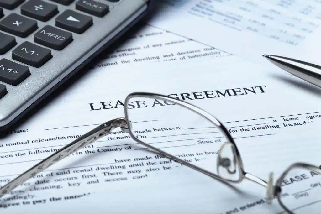 Young renter carefully reviewing a lease agreement document before signing.