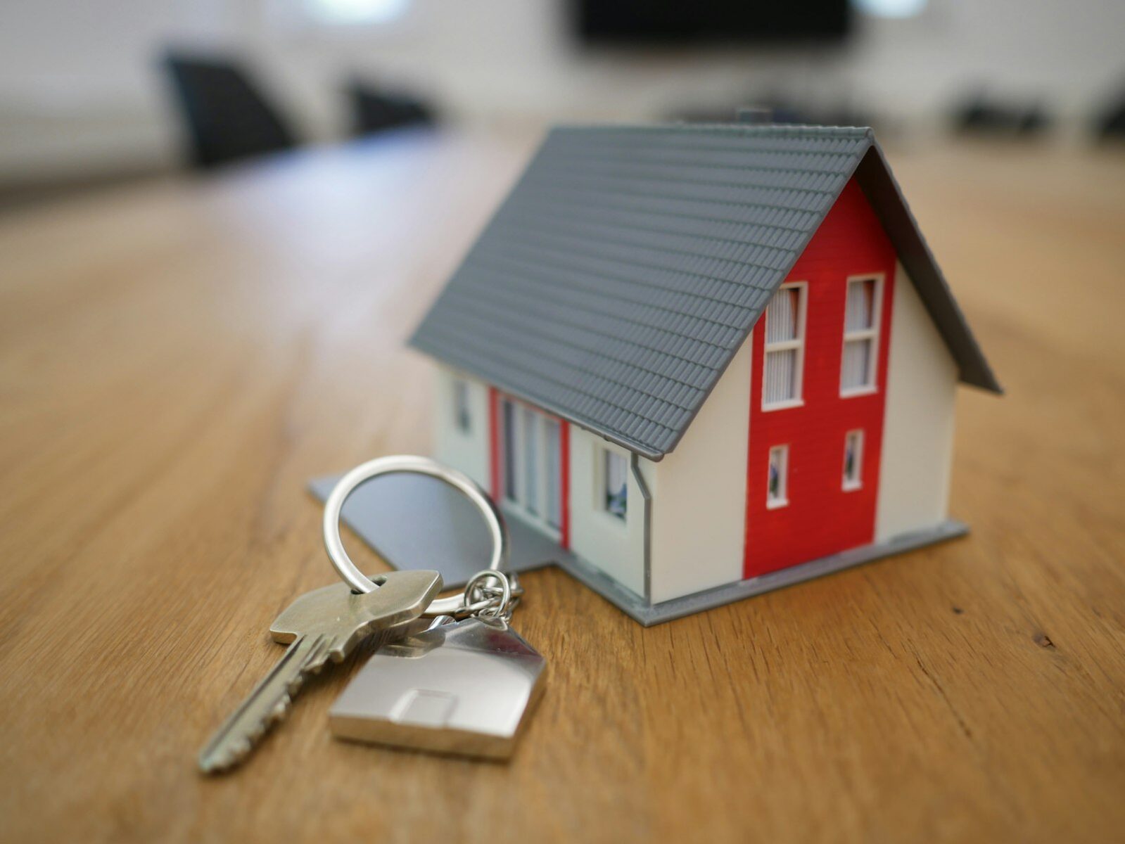 A property manager handing house keys to a smiling couple at a rental home front door.