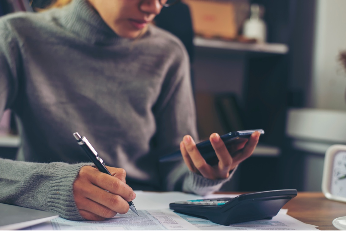 Landlord reviewing 1099 tax forms and contractor payment records for year-end filing.