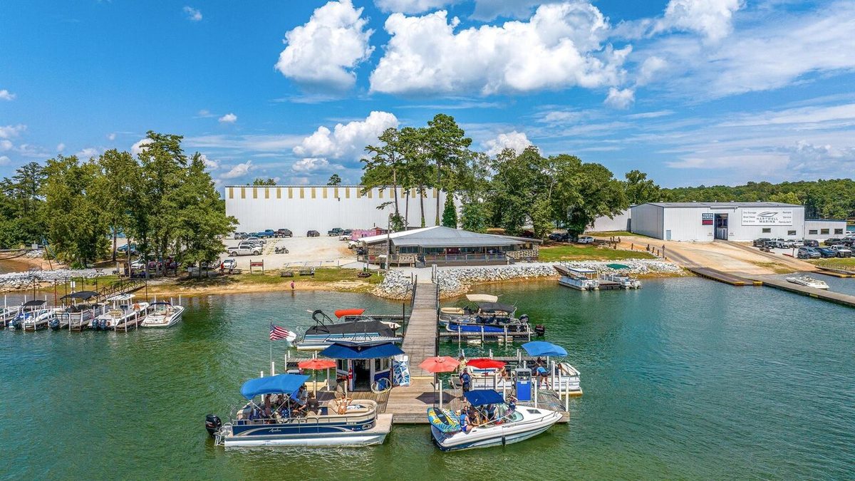 Pontoon boats docked at a Norris Lake marina on a sunny day, ready for guest rentals.
