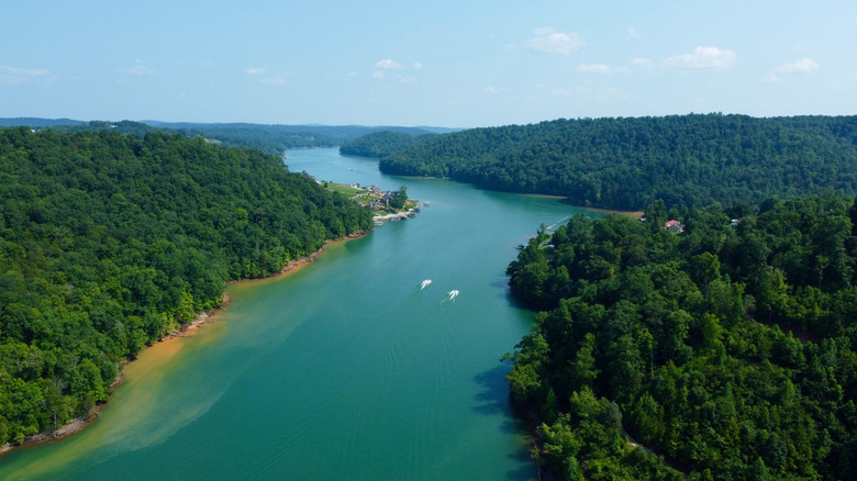 Aerial view of Norris Lake, Tennessee showing clear turquoise water, forested shoreline, and two boats on the lake.